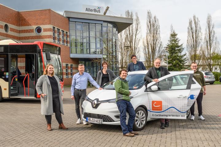 Projektbeteiligte mit einem AllerCar-Elektroauto und einem AllerBus