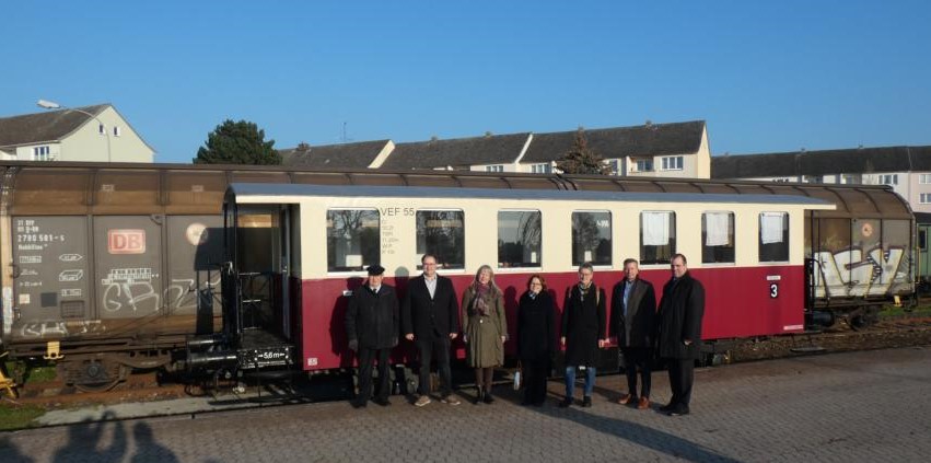 Gruppenfoto vor dem restaurierten historischen Personenwagen Nr. 55